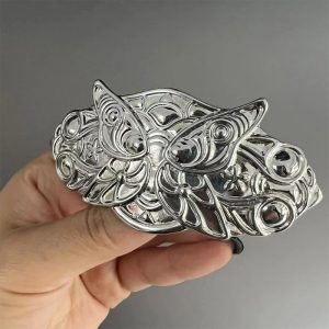 Presilha de metal prateado com borboletas da Fern, de Frieren, segurada na mão