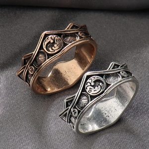 Dois anéis em forma de coroa com o dragão de três cabeças Targaryen, um bronze e outro prateado