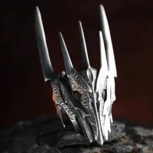 Anel em formato do elmo de espinhos de Sauron, de O Senhor dos Anéis, sobre pedra escura
