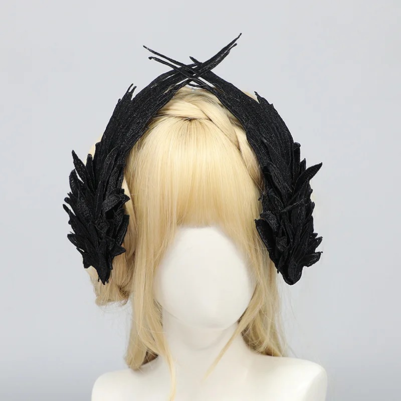 Asas pretas de penas bordadas presas no cabelo de um manequim, estilo gótico lolita