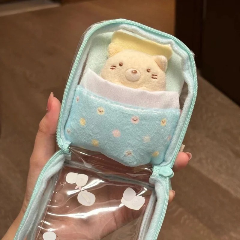 Bolsa transparente de Sumikko Gurashi aberta, mostrando o forro de PVC e a caminha com cobertor azul