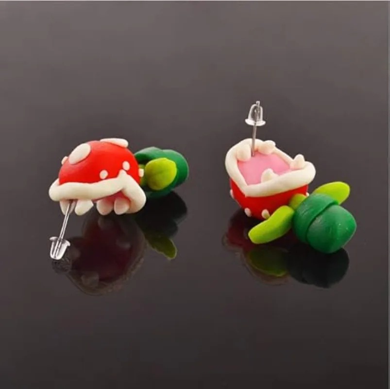 Par de brincos de argila da Planta Piranha de Super Mario sobre fundo escuro