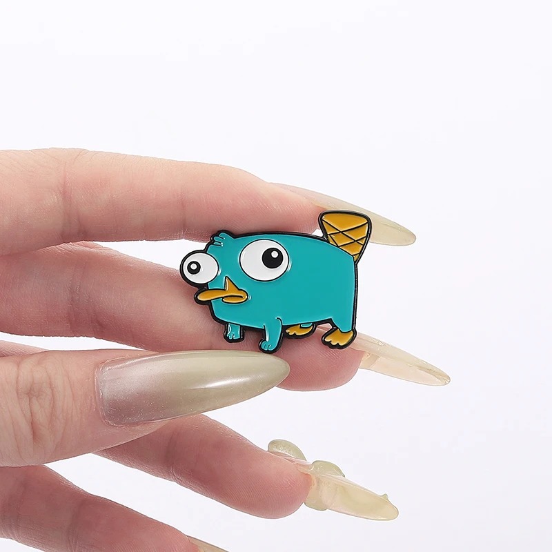 Pin esmaltado do Perry, o Ornitorrinco, de Phineas e Ferb, segurado entre os dedos