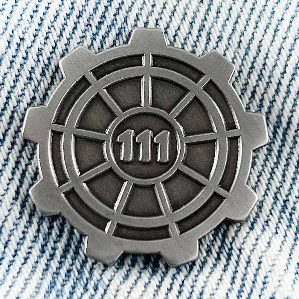 Broche de metal da porta do Vault 111, de Fallout, com engrenagem e número 111 sobre tecido jeans