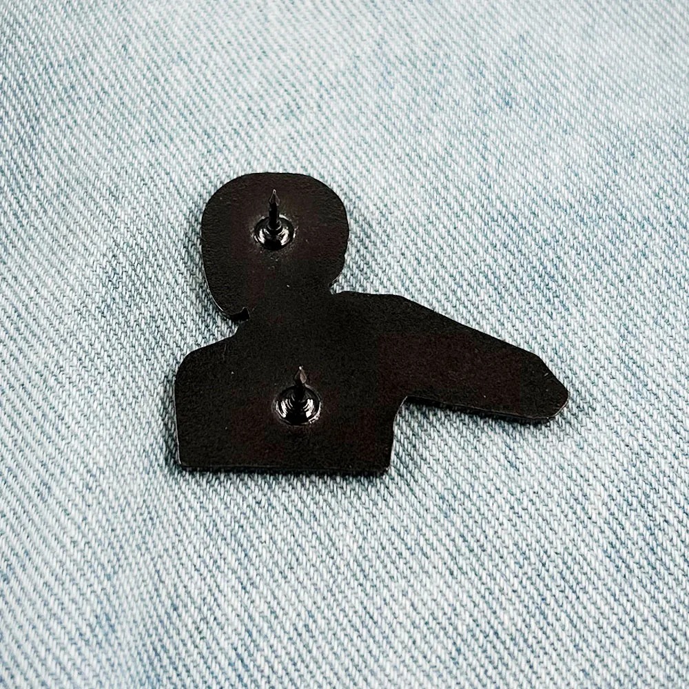Verso do broche da Reze com as travas de fixação em metal escuro