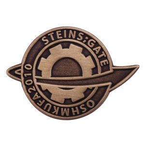 Broche de metal cor bronze com o emblema de Steins;Gate e a inscrição OSHMKUFA 2010