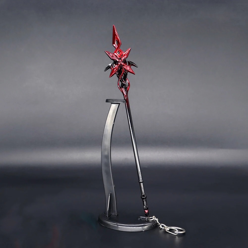 Miniatura em metal da arma da Arlecchino, de Genshin Impact, em vermelho e preto, sobre um suporte curvo