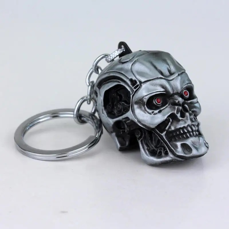 Chaveiro de metal com caveira do Exterminador do Futuro, acabamento grafite e olhos vermelhos