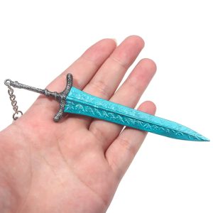 Mão segurando o chaveiro de metal da espada Dark Moon azul-turquesa, de Elden Ring