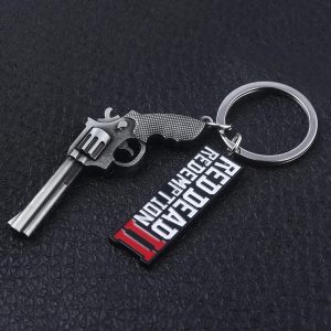 Chaveiro de metal com revólver e logo de Red Dead Redemption 2 sobre fundo escuro