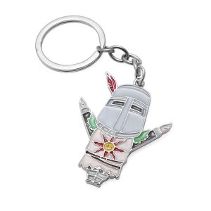 Chaveiro do Solaire de Dark Souls em metal esmaltado, com capacete, braços abertos e sol no peito, preso a uma argola