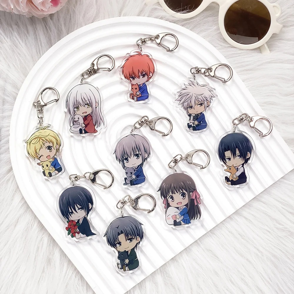 Nove chaveiros de acrílico de Fruits Basket com os personagens em estilo chibi, dispostos em um prato branco