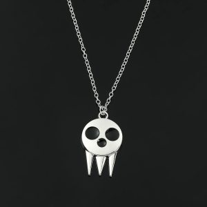 Colar prateado com pingente de caveira do Death the Kid, de Soul Eater, sobre fundo preto