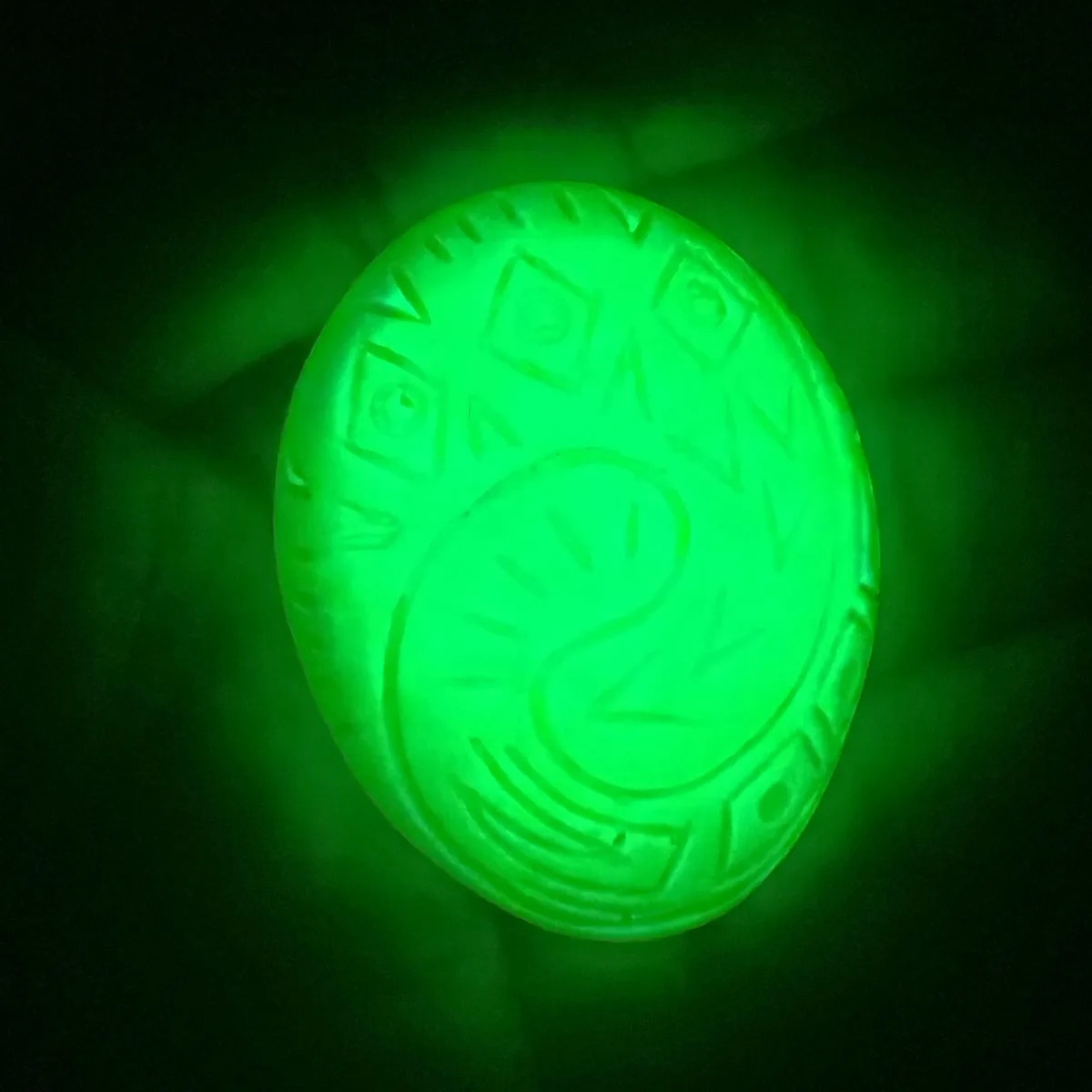 Pingente verde do Coração de Te Fiti brilhando intensamente no escuro