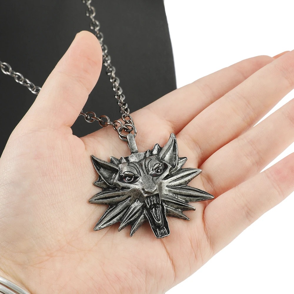 Colar de lobo, estilo The Witcher, segurado na palma da mão para mostrar o tamanho