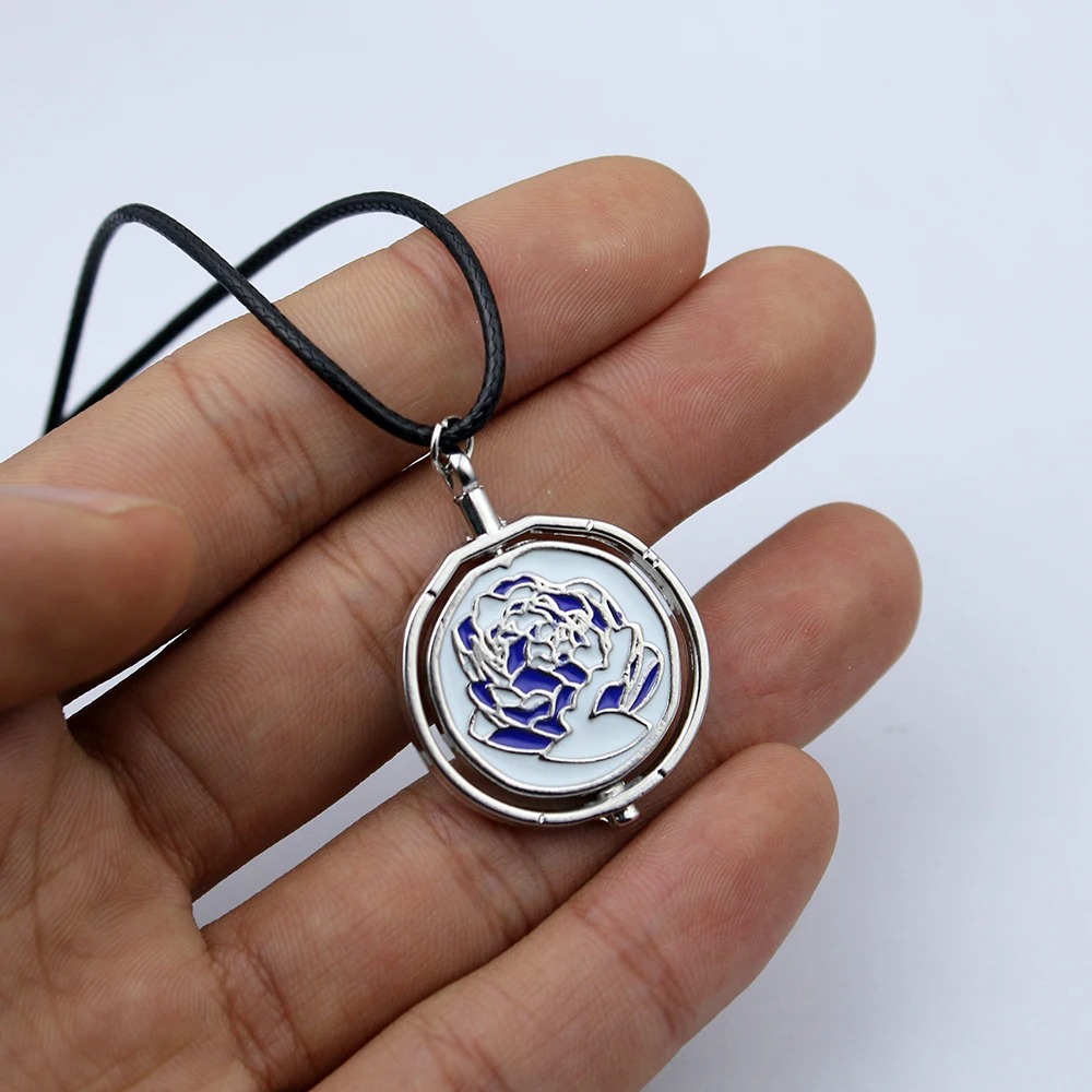 Pingente giratório da rosa azul da Jinx, de Arcane, na palma da mão com cordão preto