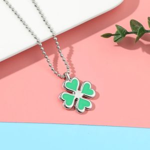 Colar com pingente de trevo de quatro folhas verde de Tokyo Revengers, sobre fundo rosa e azul