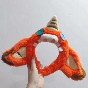 Faixa de cabelo de pelúcia laranja do Bokoblin, de Zelda, com chifre claro e botões azuis, segurada na mão