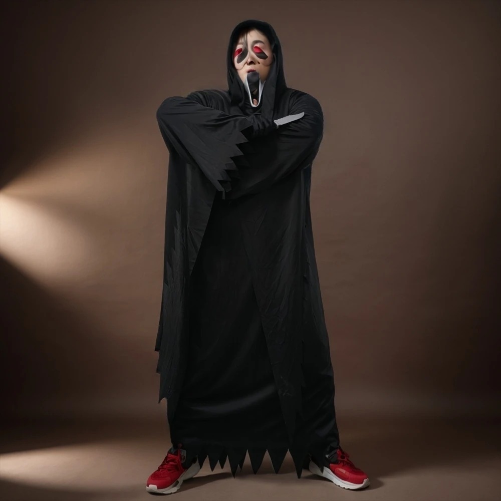 Pessoa de máscara branca alongada vestindo a túnica preta com capuz do Ghostface, de Pânico