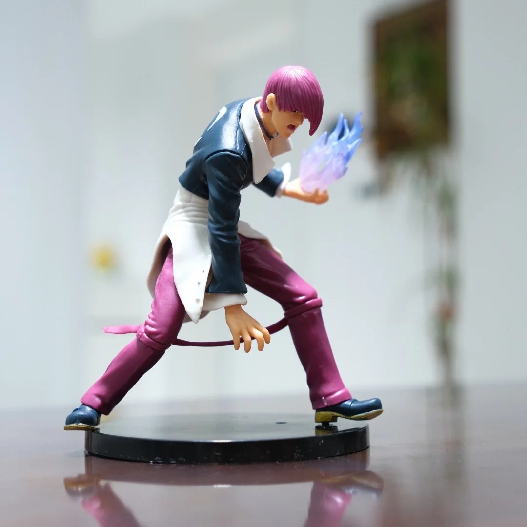 Figure do Iori Yagami de lado, com cabelo vermelho, jaqueta escura, calça roxa e chama roxa, The King of Fighters