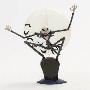 Figure do Jack Skellington, de O Estranho Mundo de Jack, em pose de salto diante da lua, sobre uma lápide