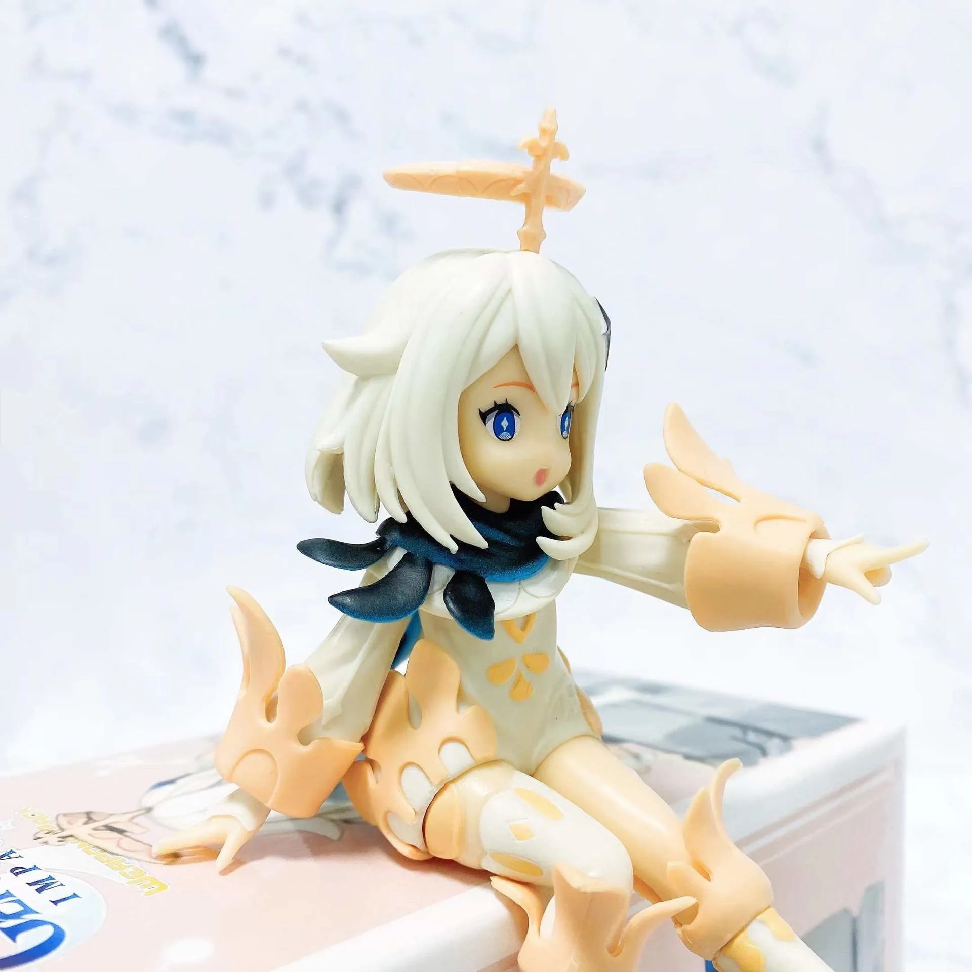 Detalhe da figure da Paimon, de Genshin Impact, com o halo e o vestido branco com detalhes dourados