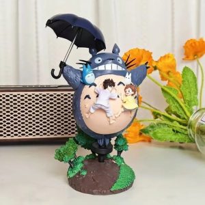 Figure do Totoro com guarda-chuva aberto e as irmãs Mei e Satsuki na barriga, de Meu Amigo Totoro