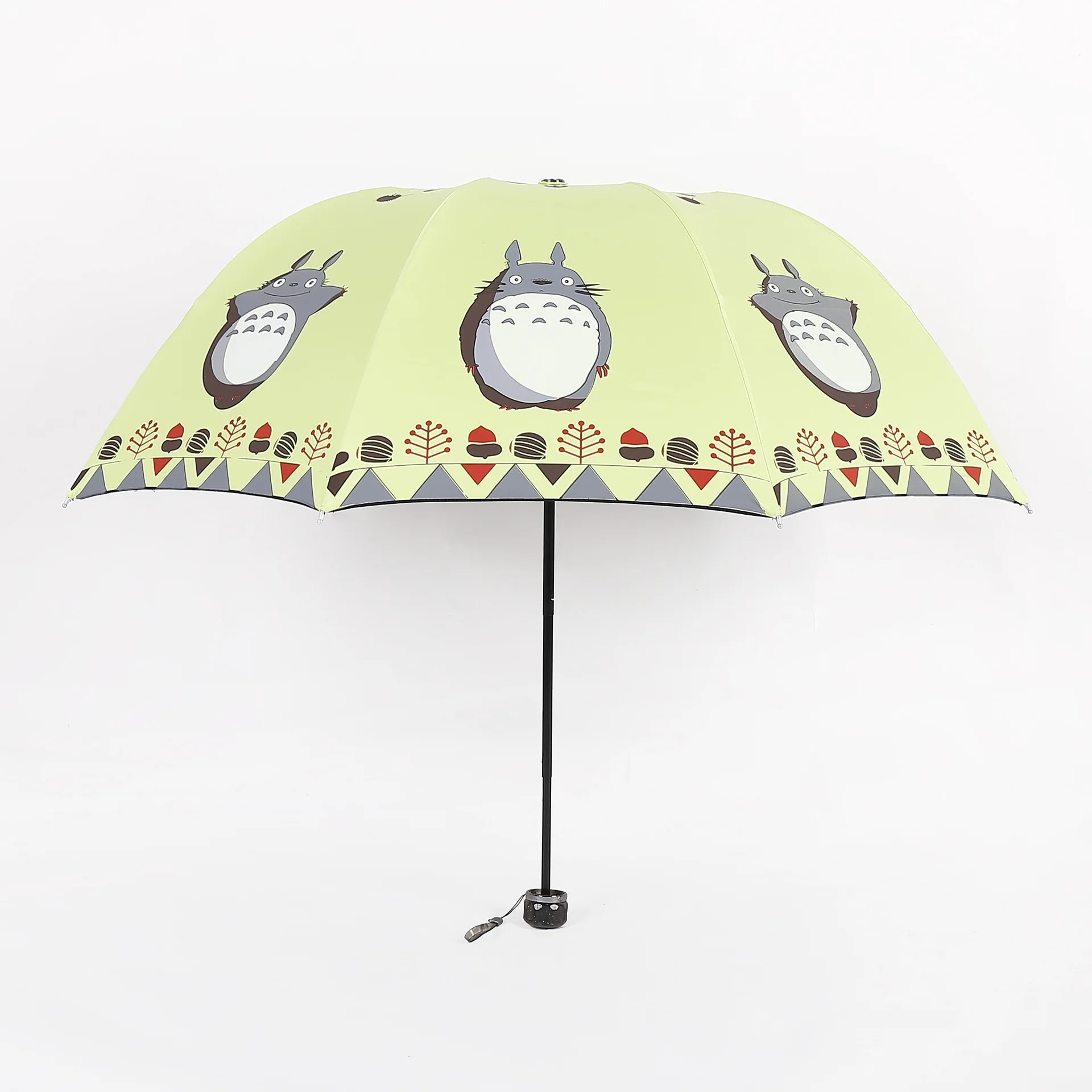 Guarda-chuva amarelo-esverdeado aberto com estampas do Totoro e faixa de detalhes na borda
