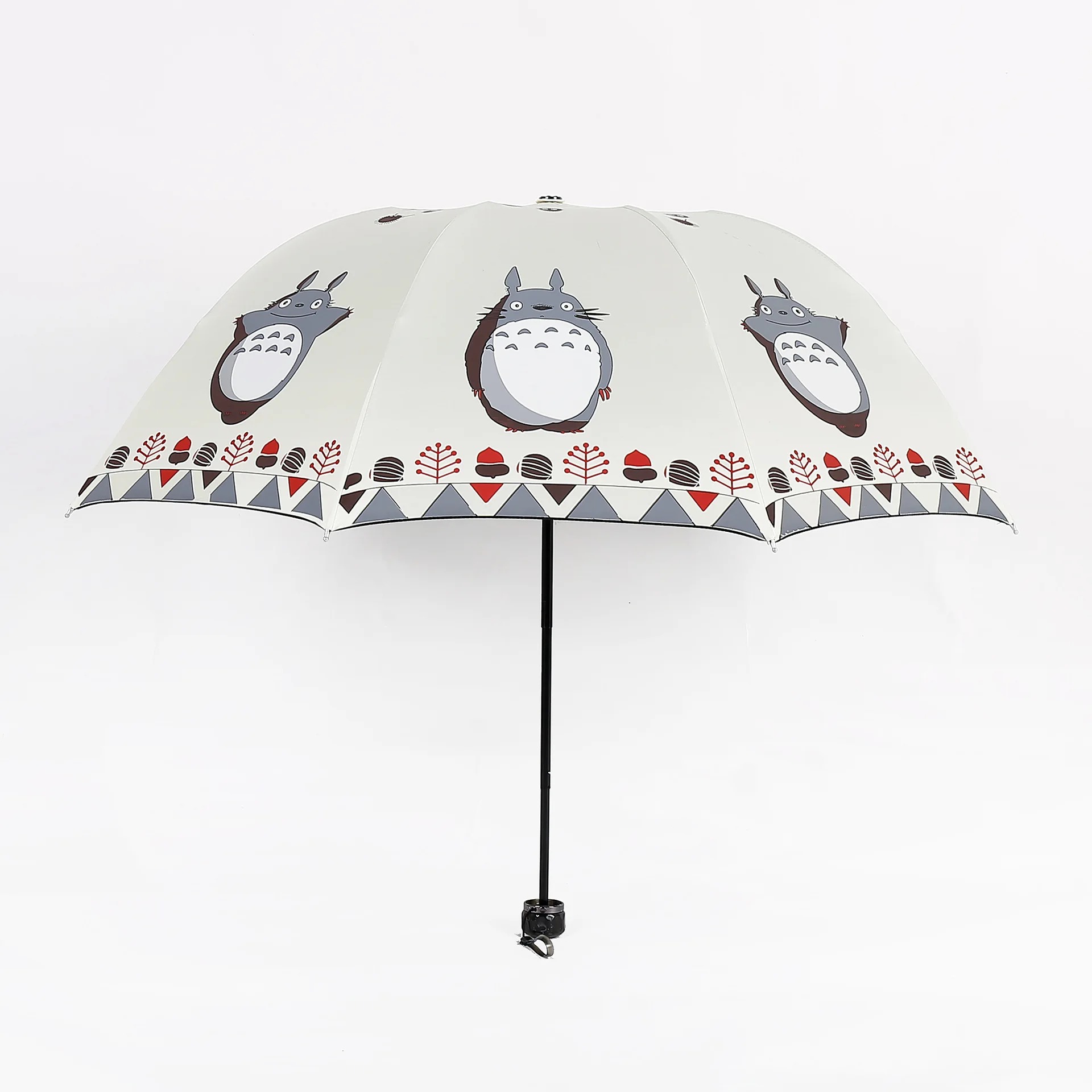 Guarda-chuva bege aberto com três Totoros estampados e cabo preto, de Meu Amigo Totoro