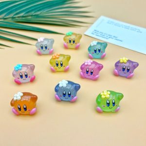 Dez miniaturas do Kirby em resina translúcida colorida sobre fundo amarelo, algumas com florzinha