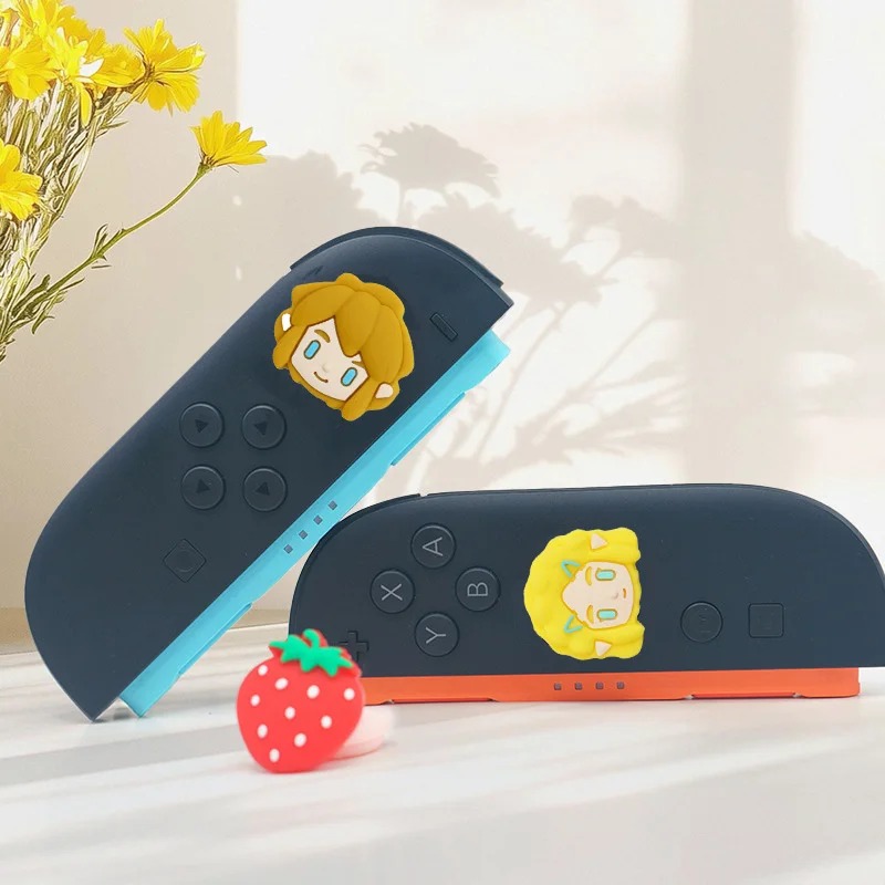 Joy-Con azul e vermelho com as capas de silicone do Link e da Zelda sobre os analógicos