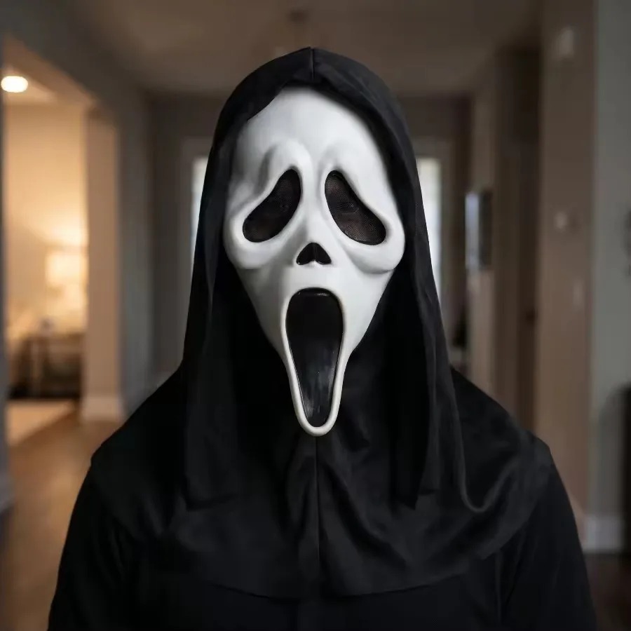Pessoa usando a máscara do Ghostface com capuz preto em um corredor, de Pânico