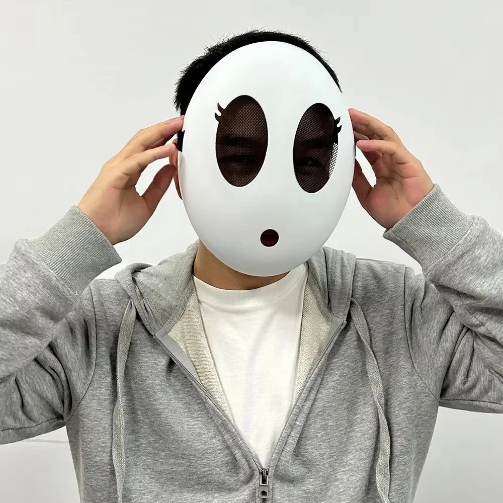 Pessoa usando a máscara do Shy Guy, de Super Mario, segurando as laterais