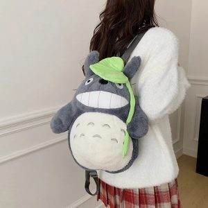 Mulher de costas usando a mochila de pelúcia do Totoro com a folha verde, de Meu Amigo Totoro