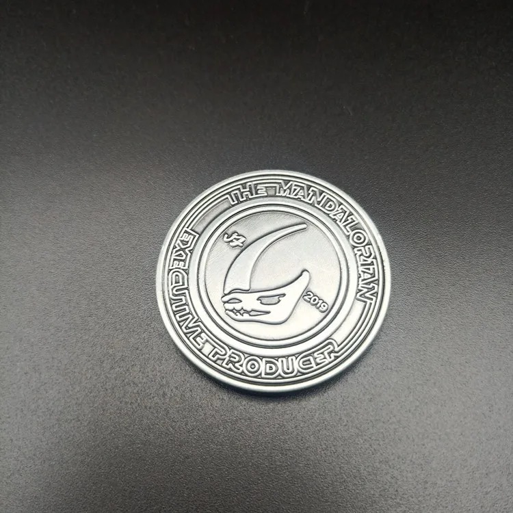 Verso da moeda de metal The Mandalorian com o mudhorn e inscrição circular em relevo