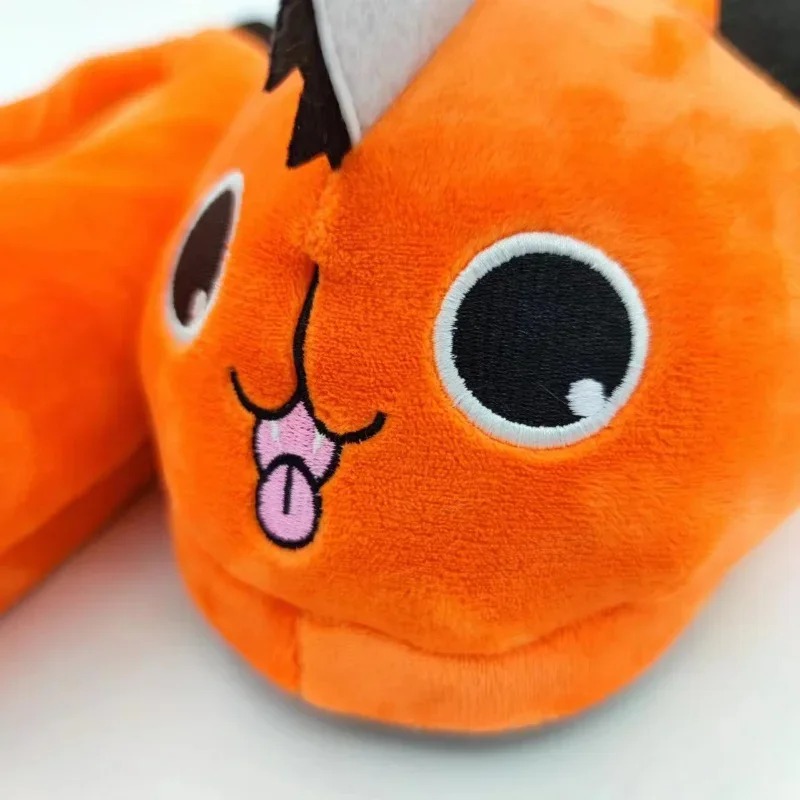 Detalhe do rosto bordado do Pochita, de Chainsaw Man, em pelúcia laranja