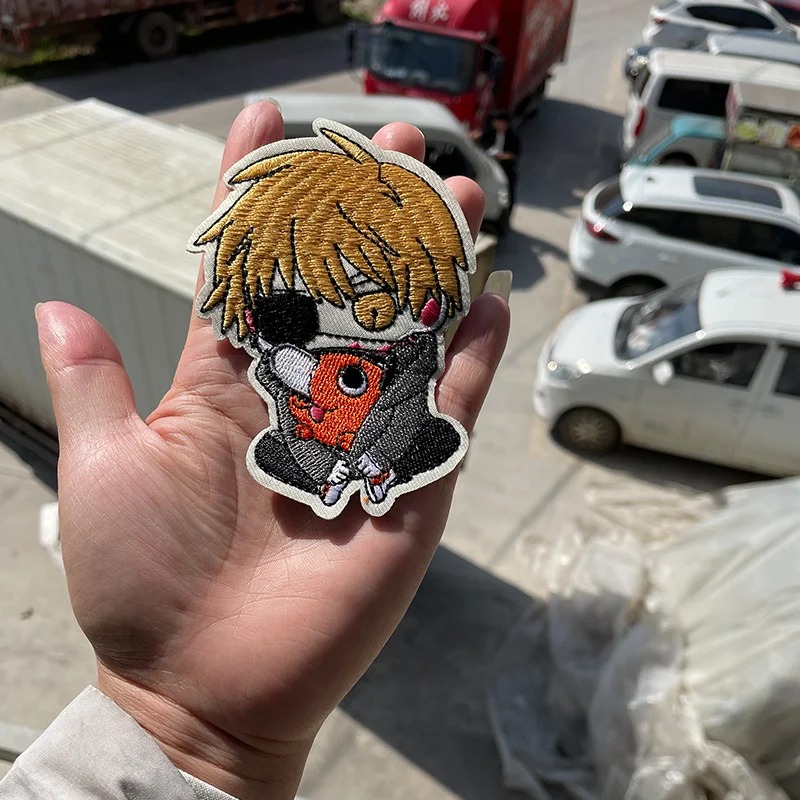 Patch bordado do Denji com o Pochita, de Chainsaw Man, segurado na mão