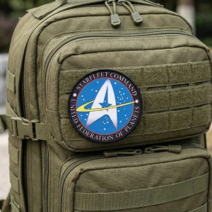 Patch redondo do Comando da Frota Estelar, de Star Trek, com seta dourada sobre fundo azul, em uma mochila verde