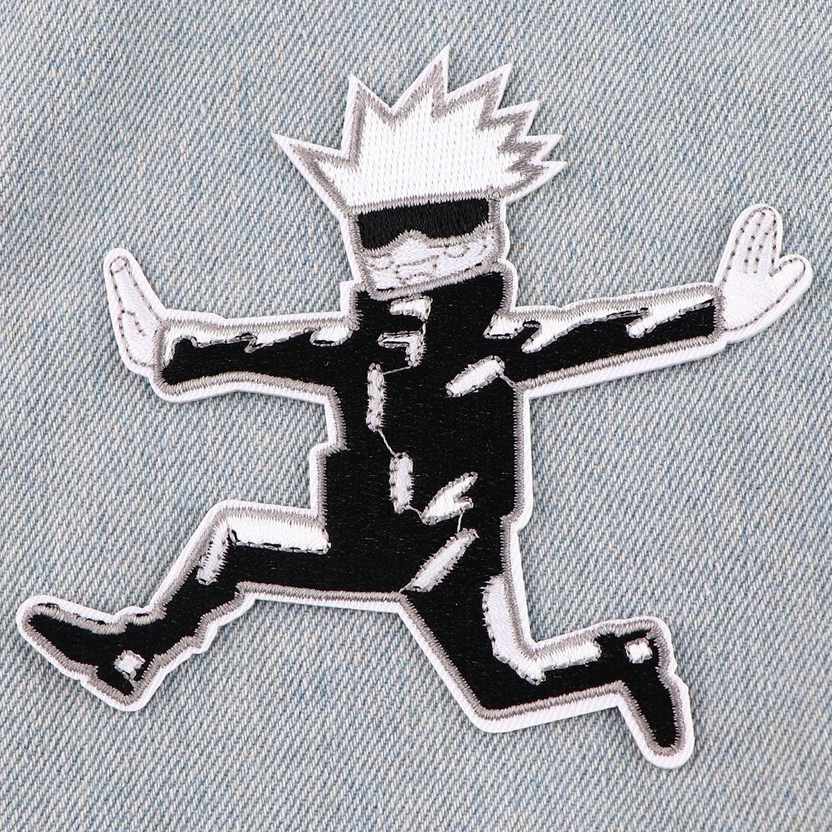 Patch do Gojo Satoru bordado em preto e branco sobre tecido jeans