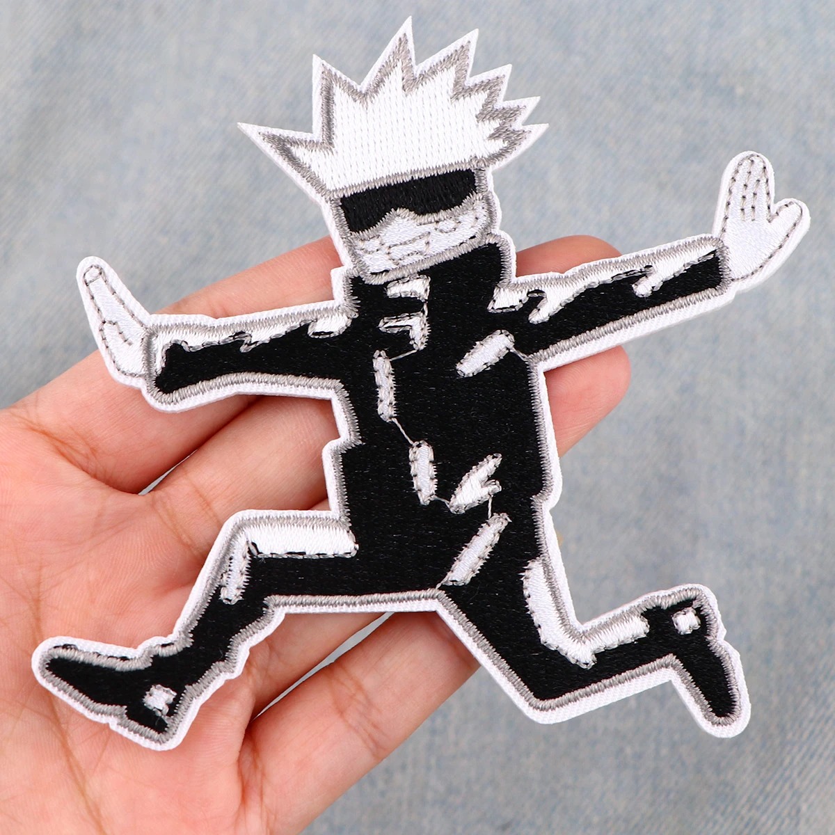 Patch do Gojo Satoru, de Jujutsu Kaisen, segurado na palma da mão para mostrar o tamanho