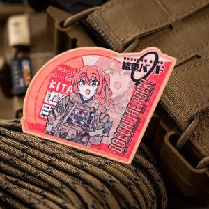 Patch da Ikuyo Kita, de Bocchi the Rock!, em tons de vermelho e rosa, sobre colete bege