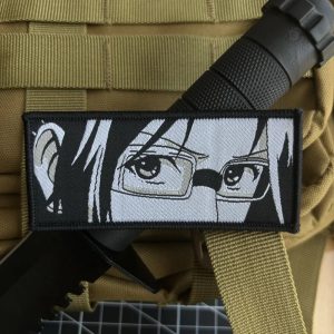 Patch retangular com os olhos da Hange Zoe, de óculos, de Attack on Titan, sobre colete bege