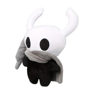 Pelúcia do Cavaleiro de Hollow Knight com cabeça branca de chifres, corpo preto e capa cinza