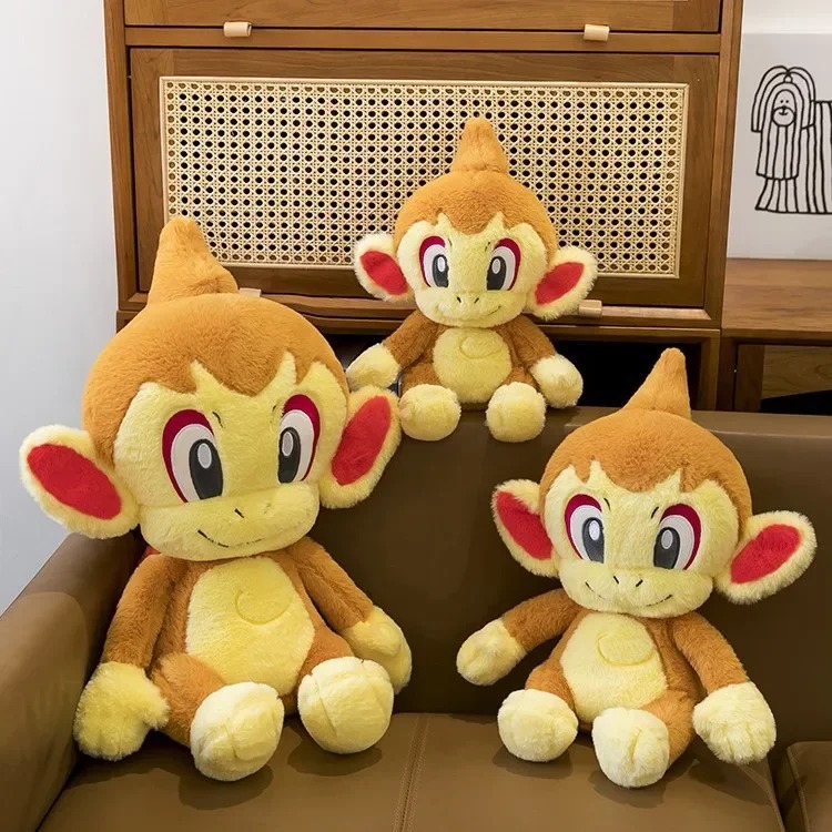 Três pelúcias do Chimchar, de Pokémon, de tamanhos diferentes sentadas em um sofá
