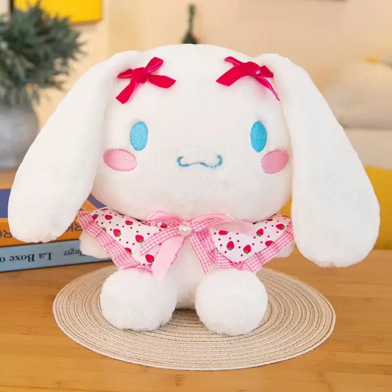 Pelúcia do Cinnamoroll com vestido branco e vermelho estampado de morangos e lacinhos vermelhos nas orelhas