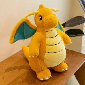 Pelúcia do Dragonite, de Pokémon, sentada sobre uma mesa de madeira, vista de frente