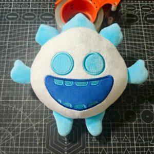 Pelúcia do Espírito de Gelo, de Clash Royale, branca e azul com boca grande sorrindo, vista de cima