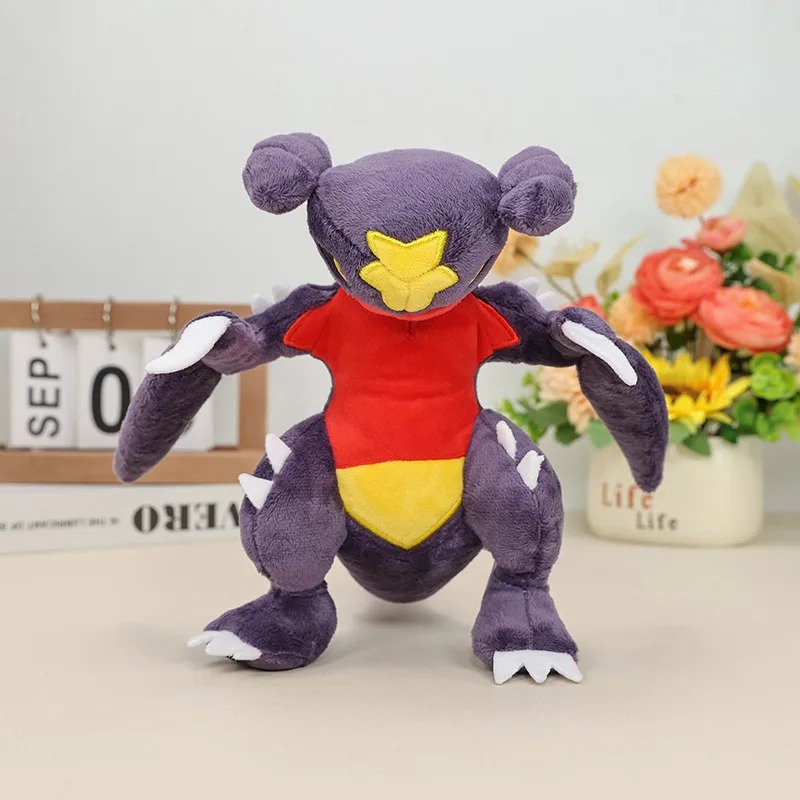 Pelúcia do Garchomp, de Pokémon, roxa, vista de frente com os braços abertos e garras brancas
