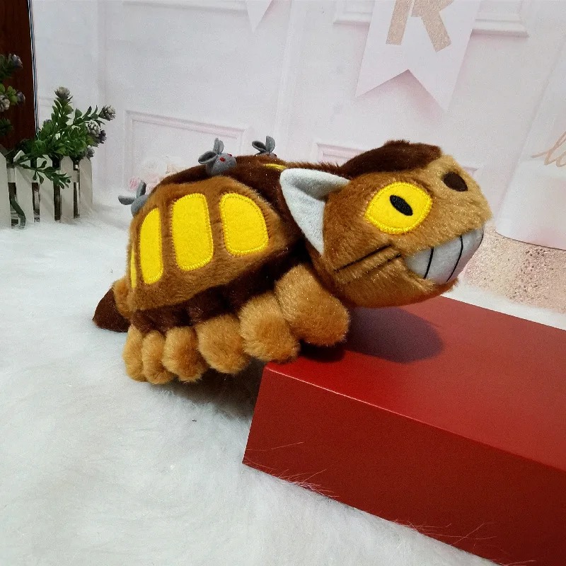 Pelúcia do Gatobus de Meu Amigo Totoro de lado, apoiada em caixa vermelha