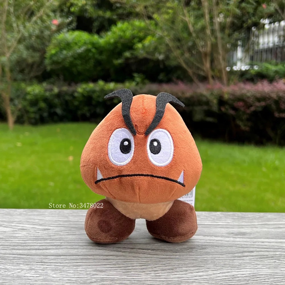 Pelúcia do Goomba de frente, com sobrancelhas pretas, presas brancas e pés marrons
